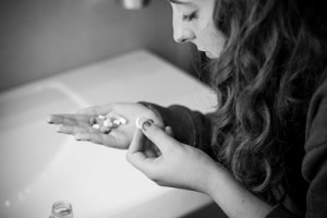 Teen girl holding a selection of pills